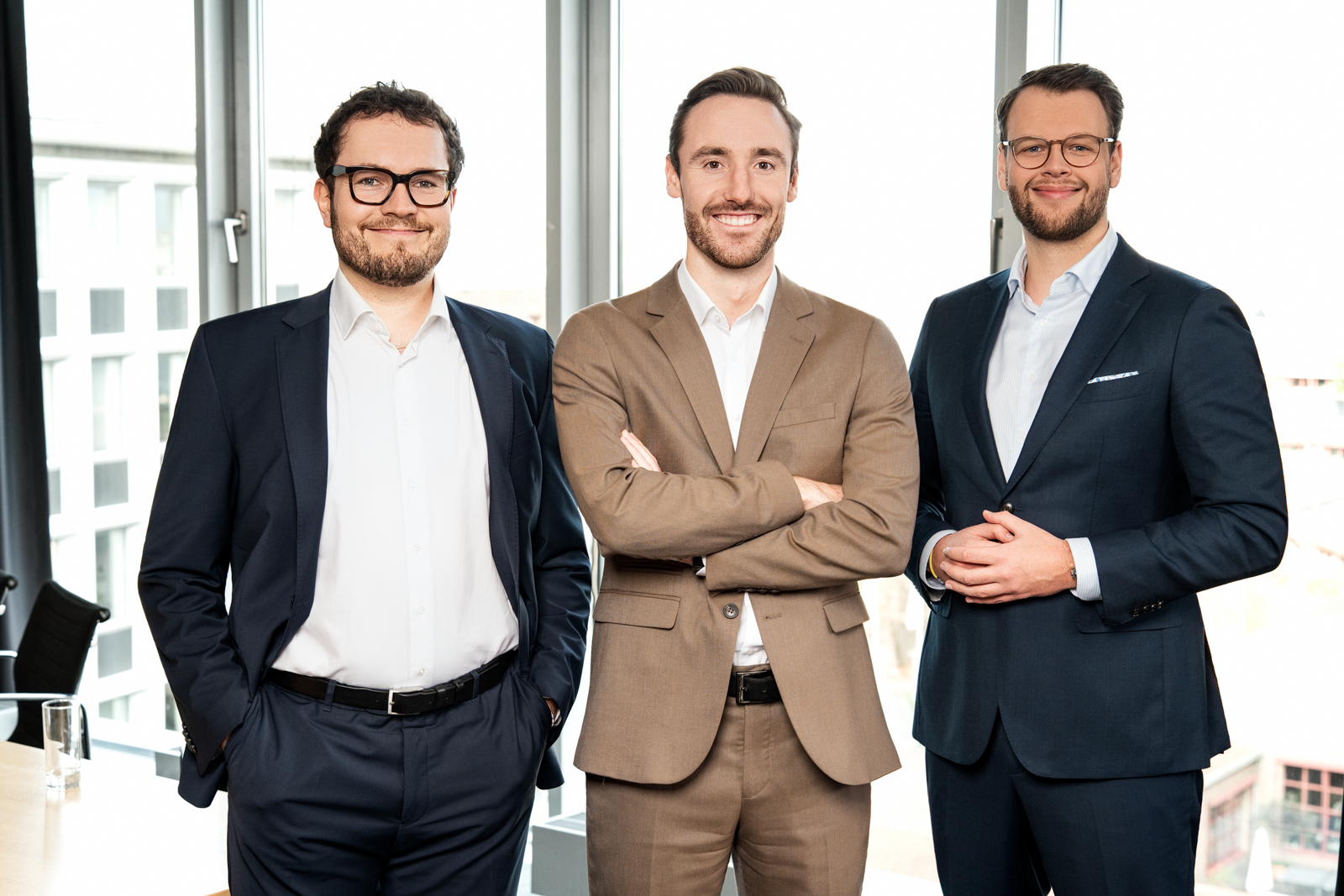 Teamfoto von drei Beratern der Ernst & Young Niederlassung Köln vor Fensterfront