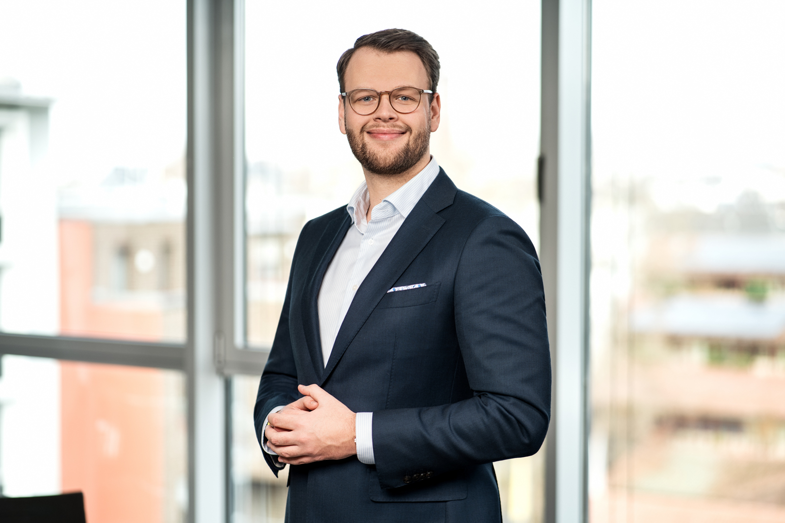 Berater im dunkelblauen Anzug mit Brille – Ernst & Young Köln