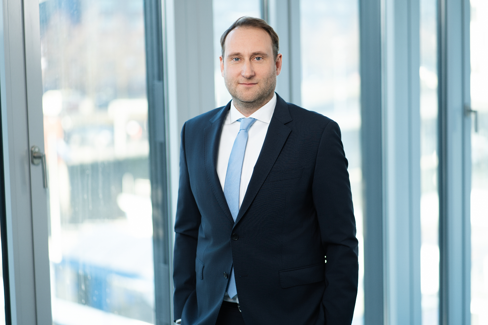 Berater im dunklen Anzug am Fenster – professionelles Mitarbeiterfoto in Köln